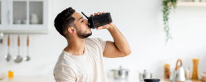 Hombre tomando suplemento dietario para complementar su dieta